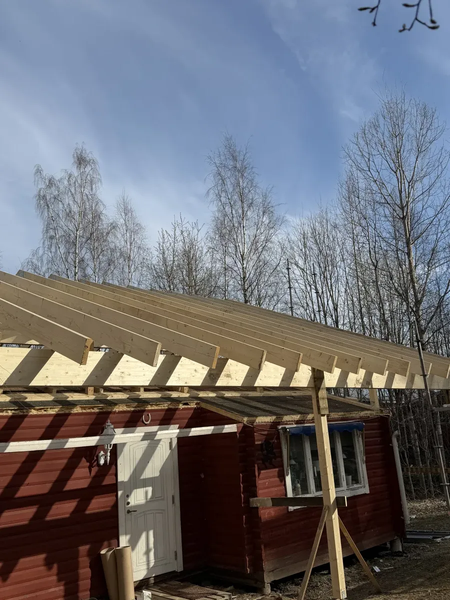 Byggställning runt rött hus under pågående takhöjning
